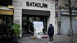 Une femme se tient devant une plaque commémorative posée à l'extérieur de la salle de concert du Bataclan où a eu lieu en novembre 2015&nbsp;une attaque&nbsp;terroriste, le 13 novembre 2019 à Paris. (STEPHANE DE SAKUTIN / AFP)